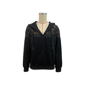 Détail du sweat à capuche noir avec empiècements en dentelle et cordons de serrage