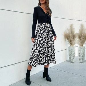 Robe élégante noire à manches longues avec col en V, jupe imprimée et détail de nœud devant