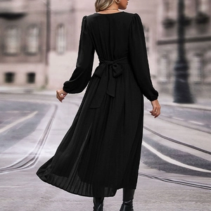 Back view of a black long-sleeve dress featuring a waist tie bow and pleated skirt detail