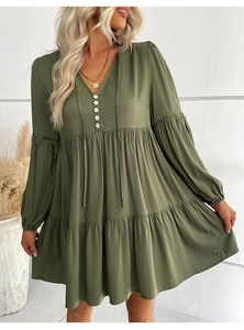Detail of dark green mini dress with crochet lace sleeves and tiered ruffled hemline