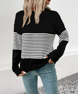 Detail of the knit texture and black and white striped pattern on a round neck sweater