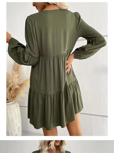 Detail of dark green tiered mini dress with long sleeves and elastic ruffled cuffs