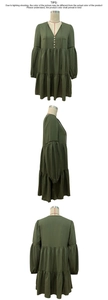 Detail view showing olive green V-neck dress with puff sleeves and tiered skirt details