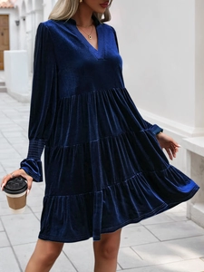 Detailed view of dark blue velvet tiered dress with delicate ruffled cuffs and soft texture