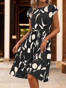 Détail de robe plissée noire avec motifs géométriques blancs et ceinture nouée