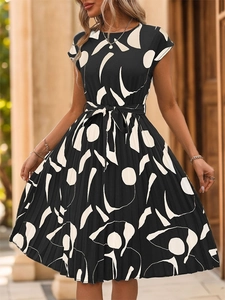 Détail d'une robe plissée à imprimé géométrique noir et blanc avec ceinture nouée