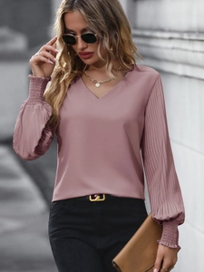 Vue détaillée du chemisier chic à col en V avec des manches bouffantes plissées rose poudré