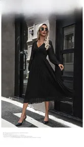 Detail of elegant V-neck pleated long sleeve midi dress showing high waist and fluid fabric