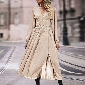 Detail of champagne pleated long sleeve dress featuring deep V-neck and waist wrap tie