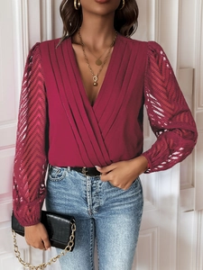 Detail of burgundy V-neck bodysuit showing pleated texture and sheer lace sleeves