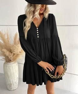 Detail of V-neckline with decorative white buttons and drawstring on a black dress