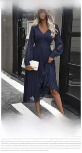Detail of navy blue pleated dress featuring textured fabric and long sleeves for women