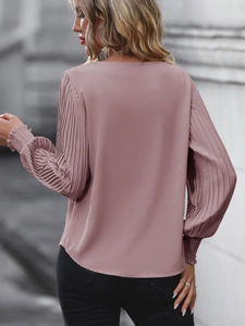 Vue détaillée du dos d'une blouse en mousseline mauve avec des manches plissées
