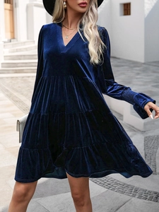 Macro detail of royal blue velvet dress showing V-neckline and layered tiered skirt texture