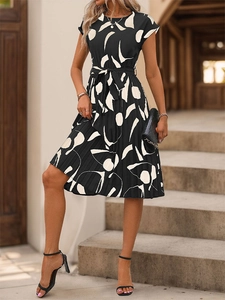 Détail d'une robe plissée à imprimé géométrique avec ceinture assortie et col rond