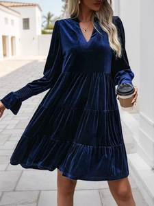 Detail of navy blue velvet dress featuring a deep V-neckline and layered ruffle skirt