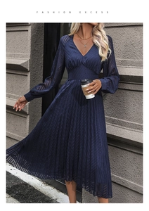 Detail of navy blue V-neck midi dress with pleated skirt and sheer textured sleeves