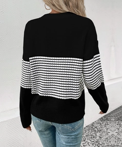 Detail of the black and white striped knit sweater showing drop shoulder design and texture