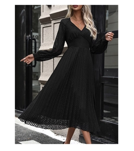 Detail of V-neck pleat design and textured fabric on a black long sleeve midi dress