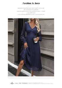 Detailed view of the dark blue pleated midi dress with V-neck and wave-textured chiffon fabric
