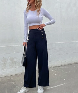 Detail of high-waisted navy wide-leg trousers with decorative golden double buttons