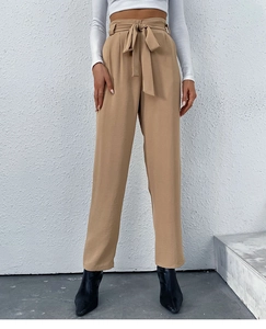 Detail of khaki high-waisted paperbag trousers with a matching tie-waist bow belt