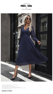 Detail of navy blue V-neck pleated midi dress with sheer long sleeves and textured pattern