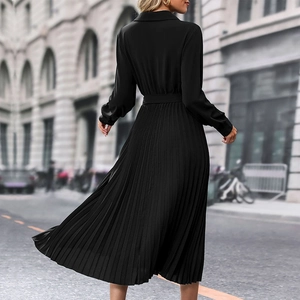 Rear view of elegant black long-sleeve pleated midi dress with tie waist in urban setting