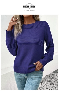 Detail of dark blue knit sweater showing ribbed cuffs and raised stripe textures