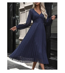 Detailed view of the sheer lantern sleeves and navy blue pleated texture on the dress