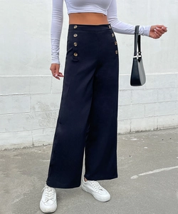 Close-up of high-waist black wide-leg trousers featuring decorative double-breasted gold buttons
