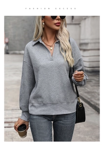 Detailed view of the grey V-neck textured sweatshirt featuring geometric embossed patterns
