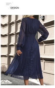 Detail of navy blue pleated dress with sheer chevron patterned long sleeves and waist tie