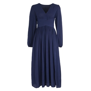 Detail of V-neckline and waist wrap design on a navy blue long sleeve pleated dress
