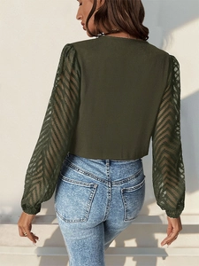 Detail of dark green top featuring sheer mesh long sleeves with wavy texture pattern
