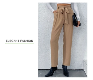 Close-up of elegant high-waisted khaki pants with a stylish tied bow and pleated waist detail