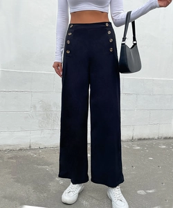 Detail view of high waisted wide leg trousers featuring double breasted gold buttons in black