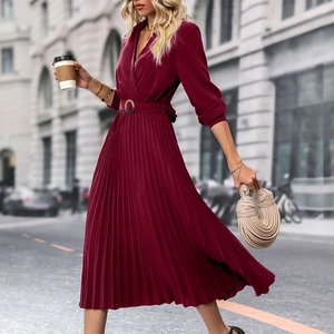 Detail of wine red lapel dress featuring elegant pleated skirt and matching belt buckle