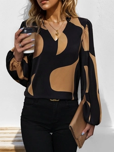 Detail of V-neck blouse featuring abstract geometric prints and elegant lantern sleeves