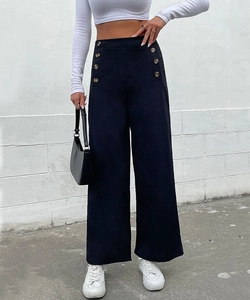 Close-up of high-waist black wide-leg trousers with decorative gold buttons and a casual fit