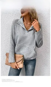 Detailansicht eines grauen gesteppten Sweatshirts mit Stehkragen und Druckknöpfen