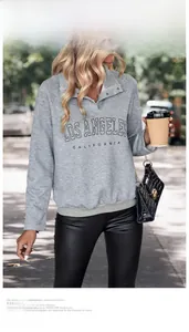 Outdoor street style shot of a grey textured waffle sweatshirt with Los Angeles lettering
