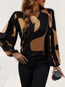 Detail of V-neckline and abstract geometric pattern on long sleeve blouse