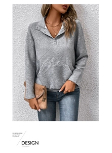 Detail eines grauen Hoodies mit Diamant-Prägung und Stehkragen mit Knopfleiste