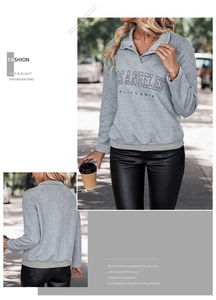Detail of grey textured sweatshirt with polo collar, metal buttons and city letter print
