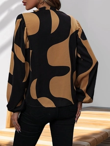 Detail view of the elegant lantern sleeve and geometric print on this silky blouse