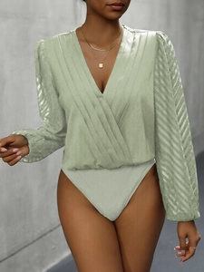 Detailed view of light green V-neck bodysuit with pleated wrap front and sheer sleeves