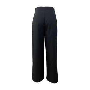 Close-up of black high-waisted wide-leg trousers showing sleek tailoring and draped fabric