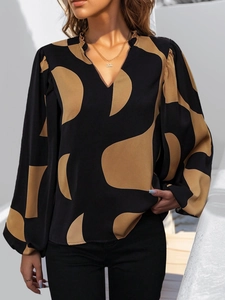Detail of V-neck ruffled collar and geometric print on a long-sleeve blouse