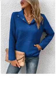 Detailansicht der dunkelblauen Steppstruktur und Knopfkragen an Langarm-Pullover